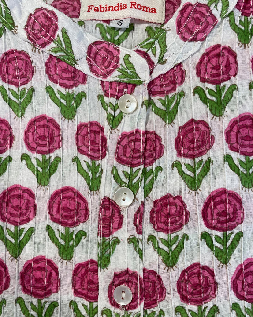 Tessuto cotone pintuck dettaglio pieghe rose fucsia foglie verdi e boccioli su fondo bianco