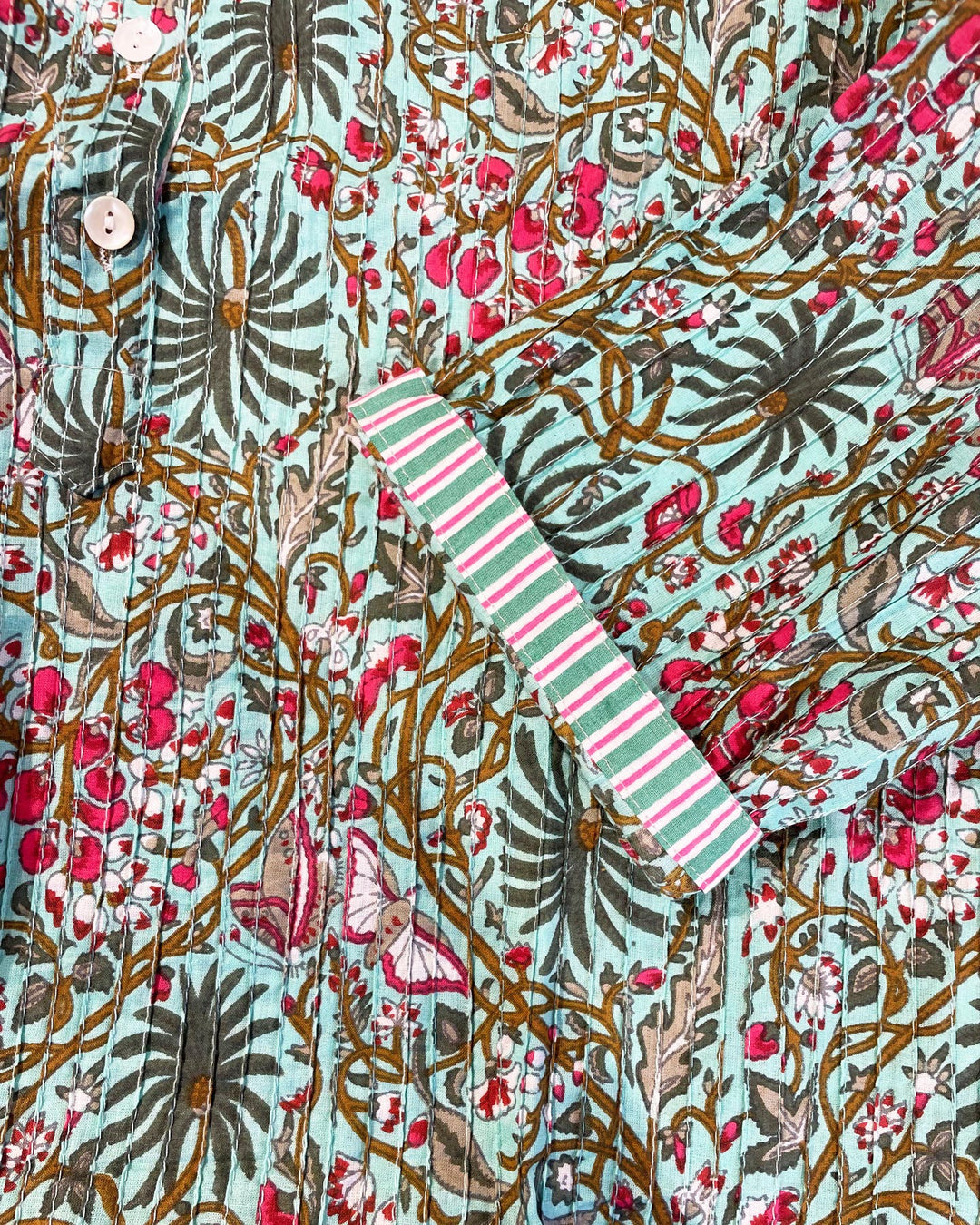 Tessuto cotone pintuck dettaglio pieghe foglie monstera fiori magenta e farfalle su turchese