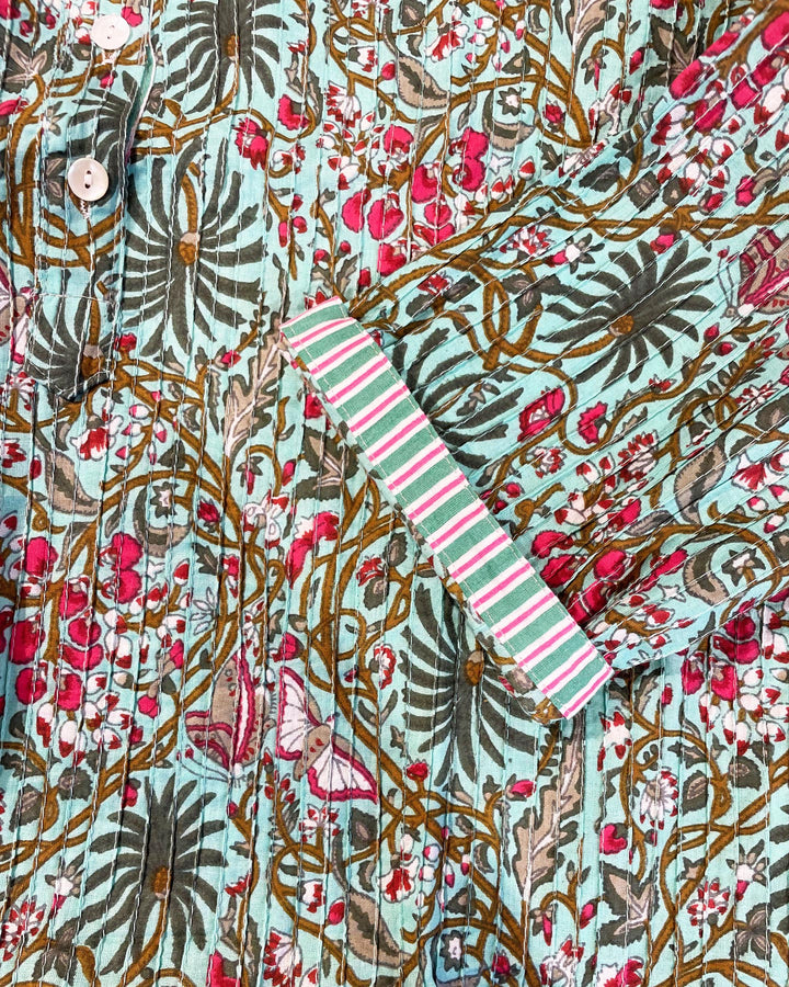 Tessuto cotone pintuck dettaglio pieghe foglie monstera fiori magenta e farfalle su turchese