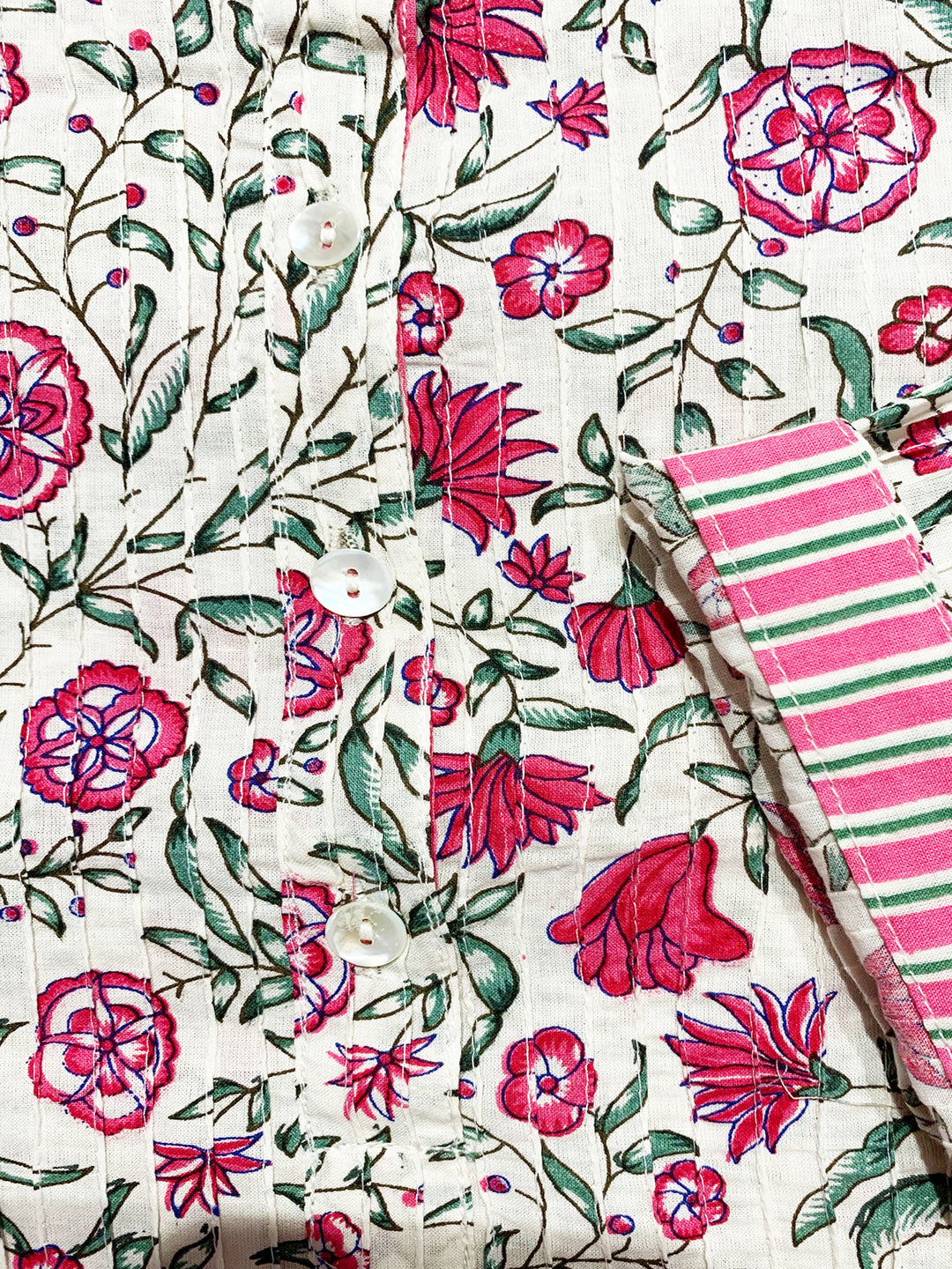 Tessuto cotone pintuck dettaglio pieghe rose magenta foglie verdi su fondo bianco panna