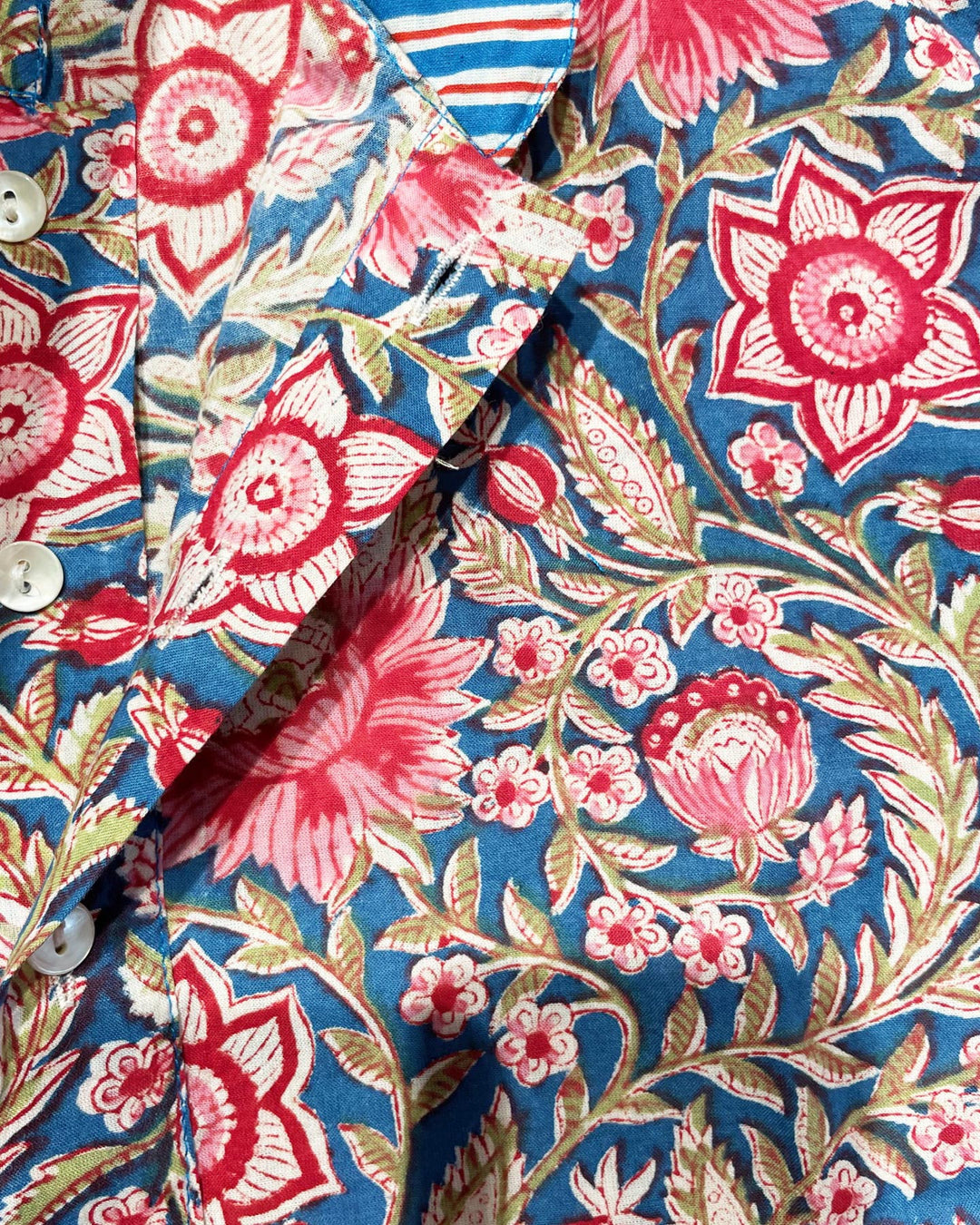 Tessuto cotone indiano stampato fiori rosa corallo e rami verdi su fondo blu majorelle
